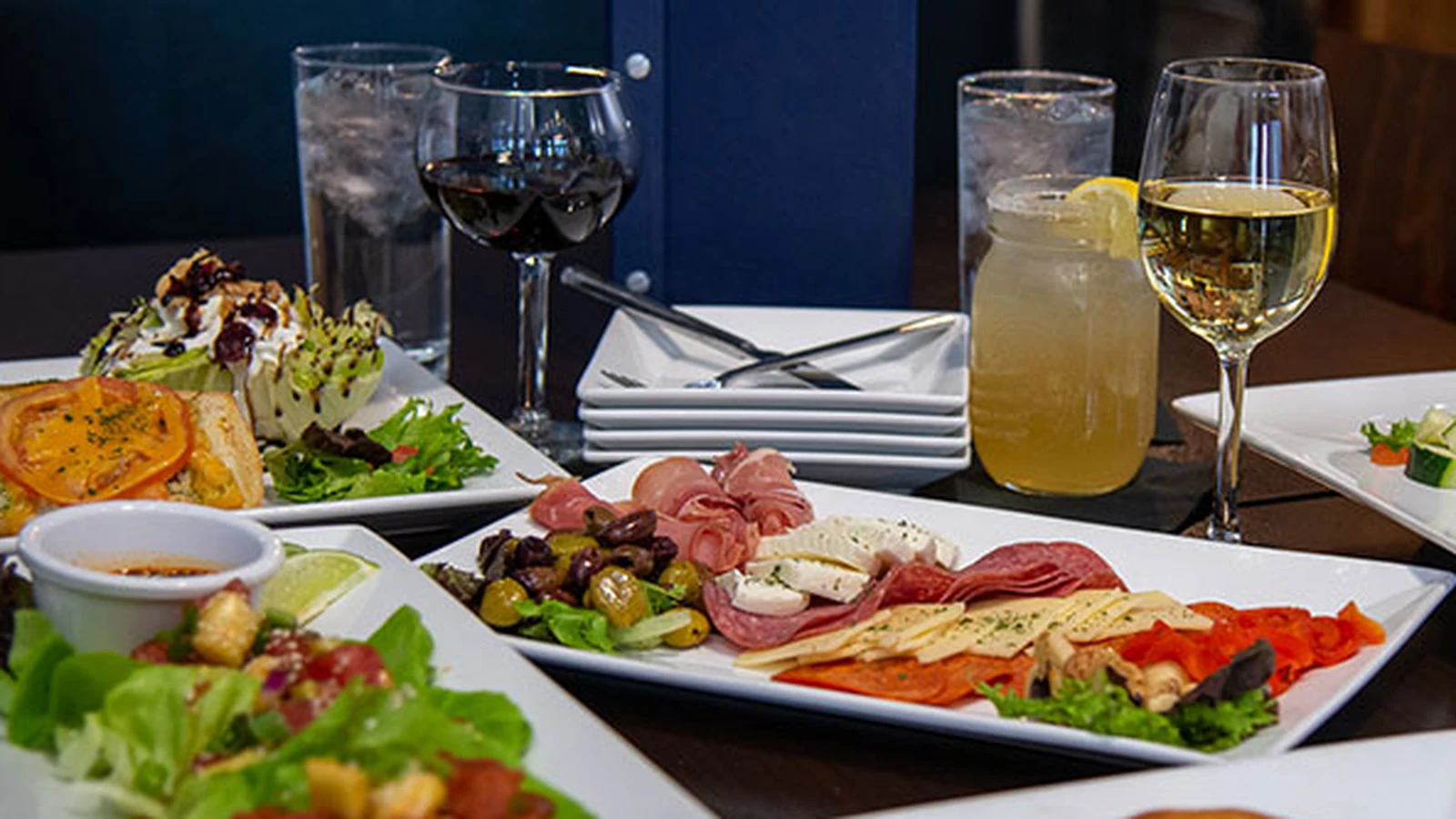 A table set with food, wine and drinks at an 842 Group restaurant